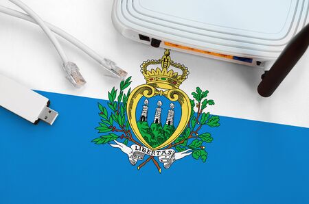 San Marino flag depicted on table with internet rj45 cable, wireless usb wifi adapter and router....