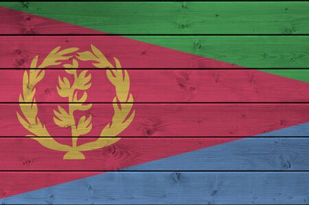 Eritrea flag depicted in bright paint colors on old wooden wall close up. Textured banner on rough backgroundの写真素材