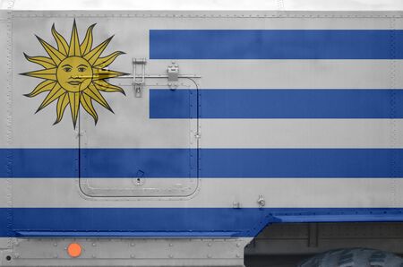 Uruguay flag depicted on side part of military armored truck close up. Army forces vehicle...