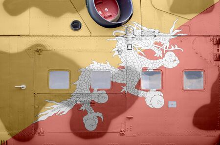 Bhutan flag depicted on side part of military armored helicopter close up. Army forces aircraft...