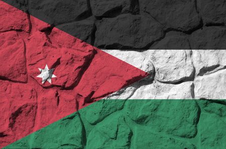 Jordan flag depicted in paint colors on old stone wall close up. Textured banner on rock wall backgroundの写真素材