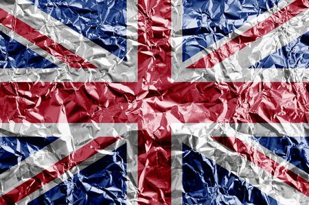 Great britain flag depicted in paint colors on shiny crumpled aluminium foil close up. Textured banner on rough backgroundの写真素材