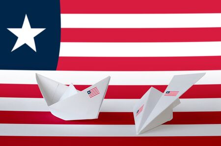 Liberia flag depicted on paper origami airplane and boat. Oriental handmade arts concept