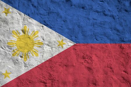 Philippines flag depicted in bright paint colors on old relief plastering wall close up. Textured banner on rough backgroundの写真素材