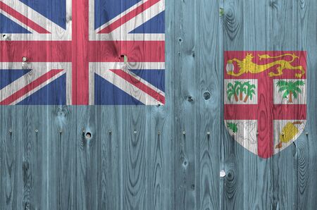 Fiji flag depicted in bright paint colors on old wooden wall close up. Textured banner on rough backgroundの写真素材