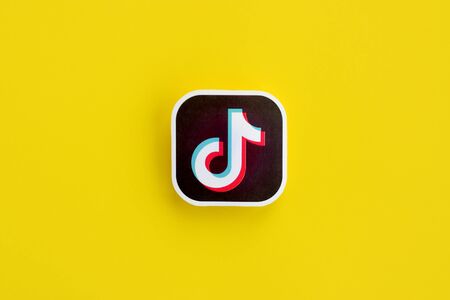 NY, USA - DECEMBER 5, 2019: Tiktok paper logo on yellow background. TikTok is a popular video-sharing social networking service owned by ByteDanceのeditorial素材