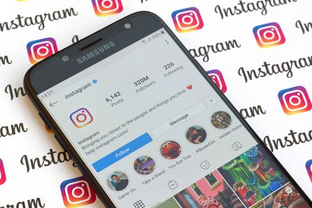 NY, USA - DECEMBER 4, 2019: Main official instagram account on smartphone screen on paper instagram banner.のeditorial素材
