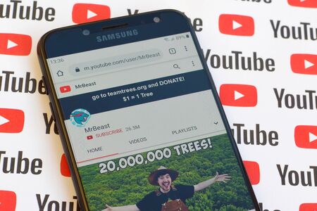 NY, USA - DECEMBER 4, 2019: MrBeast official youtube channel on smartphone screen on paper youtube background.のeditorial素材