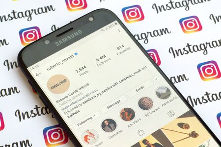 NY, USA - DECEMBER 4, 2019: Roberto Cavalli official instagram account on smartphone screen on paper...