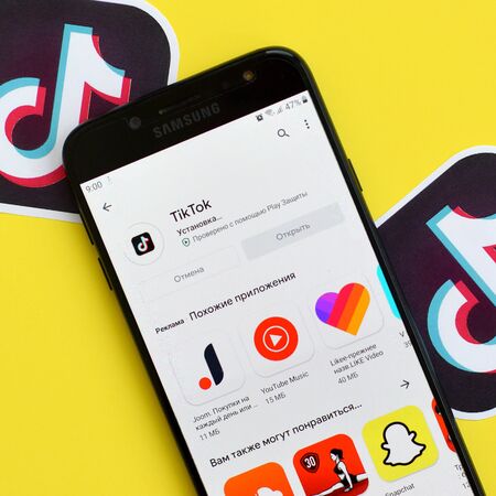 NY, USA - DECEMBER 5, 2019: Tiktok application in playmarket on samsung smartphone screen on yellow...