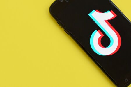 NY, USA - DECEMBER 5, 2019: Tiktok logo on samsung smartphone screen on yellow background. TikTok is...