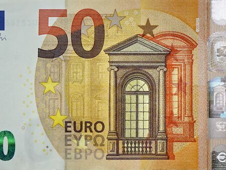 Fragment part of 50 euro banknote close-up with small brown details. European currency bill