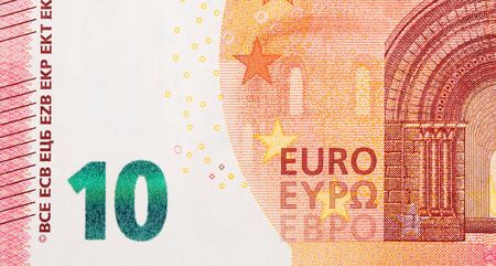 Fragment part of 10 euro banknote close-up with small red details. European currency bill