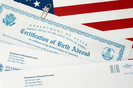 Fs-545 Certification of birth abroad lies on United States flag with envelope from Department of Homeland Security close upの写真素材