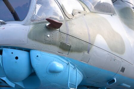 Close up view on helicopter cabin fragment. Camouflage aircraft fuselage and bulletproof glass