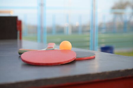 rackets and ball close up on table tennis table in outdoor sport yard. Active sports and physical training conceptの写真素材