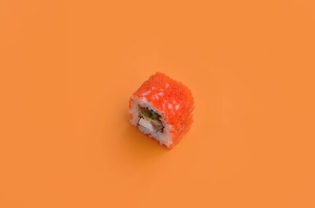 California Maki sushi roll with caviar and masago on orange background close up. Minimalism top view flat lay with Japanese foodの写真素材