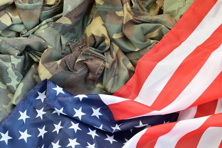 United States of America flag and folded military uniform jacket. Military symbols conceptual background banner for american patriotic holidays designの写真素材