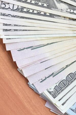 Fan of many one hundred and fifty dollar bills on wooden background surface close up. Flat lay top view. Abstract success or business conceptの写真素材