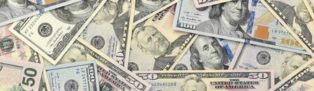 Many one hundred and fifty dollar bills on flat background surface close up. Flat lay top view....