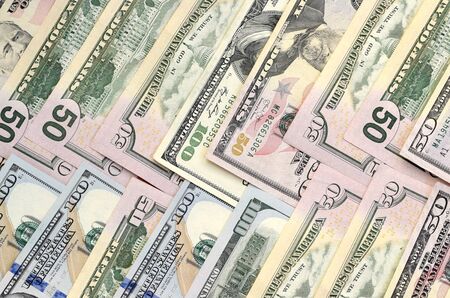 Many one hundred and fifty dollar bills on flat background surface close up. Flat lay top view....