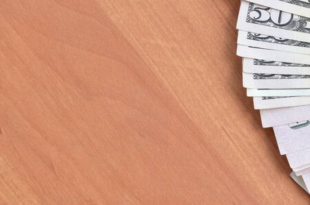 Fan of many one hundred and fifty dollar bills on wooden background surface close up. Flat lay top view. Abstract success or business conceptの写真素材