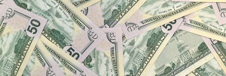 Many US fifty dollar bills on flat background surface close up. Flat lay top view. Abstract success...