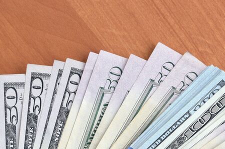Fan of many one hundred and fifty dollar bills on wooden background surface close up. Flat lay top...