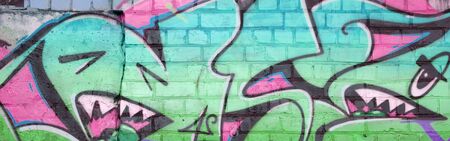 Abstract colorful fragment of graffiti paintings on old brick wall in green colors. Street art composition with parts of unwritten letters and multicolored stains. Subcultural background textureの写真素材