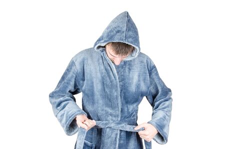Portrait of young caucasian bearded man in blue bathrobe tightening his belt isolated on white background. Recession or economic depression conceptの写真素材