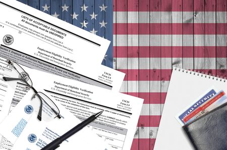 USCIS form I-9 Employment eligibility verification lies on flat lay office table and ready to fill. U.S. Citizenship and Immigration services paperwork concept. Top viewの写真素材