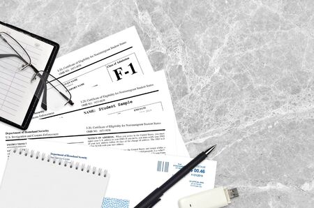 USCIS form I-20 Certificate of eligibility for nonimmigrant student status lies on flat lay office table and ready to fill. U.S. Citizenship and Immigration services paperwork concept. Top viewの写真素材