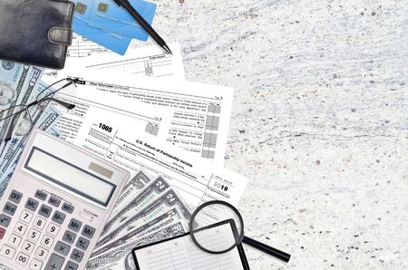 IRS form 1065 U.S. Return of partnership income lies on flat lay office table and ready to fill. U.S. Internal revenue services paperwork concept. Time to pay taxes in United States. Top viewの写真素材