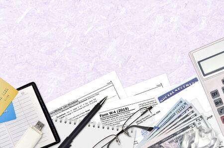 IRS form w-4 Employees Withholding Certificate lies on flat lay office table and ready to fill. U.S. Internal revenue services paperwork concept. Time to pay taxes in United States. Top viewの写真素材