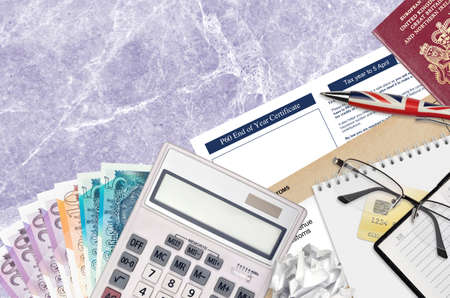 English Tax form P60 End of year certificate by HM revenue and customs lies on table with office...