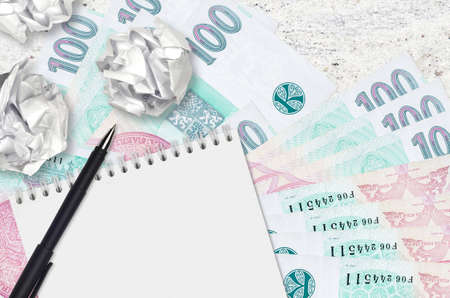 100 Czech korun bills and balls of crumpled paper with notepad. Bad ideas or less of inspiration...