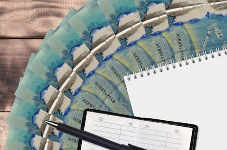 5 Canadian dollars bills fan and notepad with contact book and black pen. Concept of financial...
