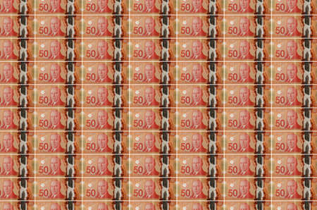 50 Canadian dollars bills printed in money production conveyor. Collage of many bills. Concept of...