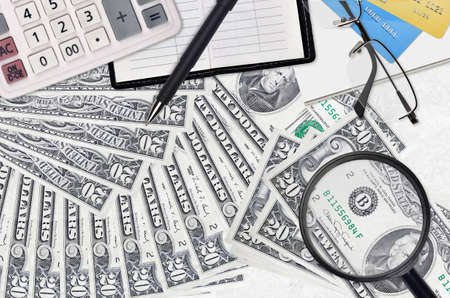 20 US dollars bills and calculator with glasses and pen. Tax payment season concept or investment...