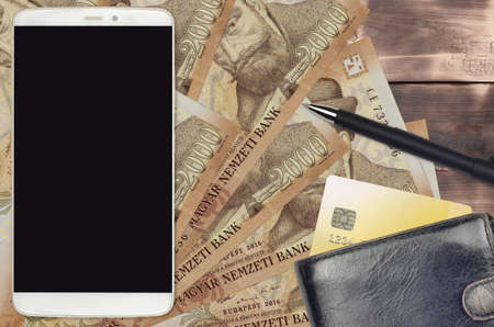 2000 Hungarian forint bills and smartphone with purse and credit card. E-payments or e-commerce...