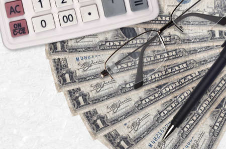 1 US dollar bills fan and calculator with glasses and pen. Business loan or tax payment season concept. Financial planningの写真素材