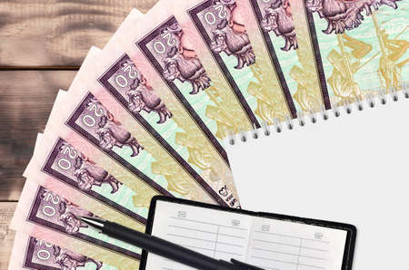20 Sri Lankan rupees bills fan and notepad with contact book and black pen. Concept of financial...