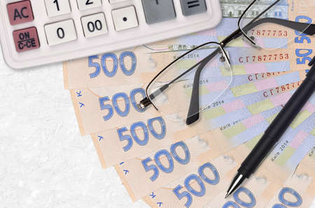 500 Ukrainian hryvnias bills fan and calculator with glasses and pen. Business loan or tax payment season concept. Financial planningの写真素材