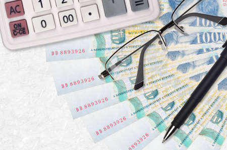 1000 Hungarian forint bills fan and calculator with glasses and pen. Business loan or tax payment...