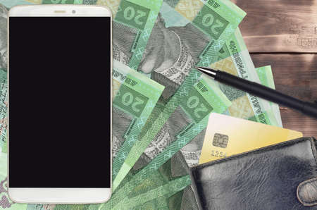 20 Ukrainian hryvnias bills and smartphone with purse and credit card. E-payments or e-commerce...