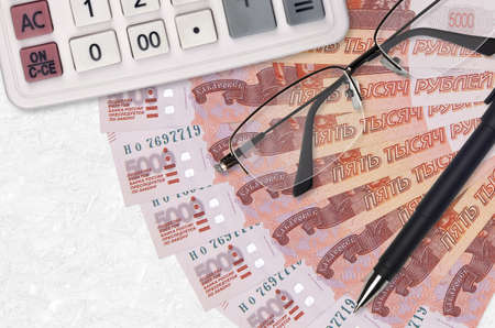 5000 russian rubles bills fan and calculator with glasses and pen. Business loan or tax payment season concept. Financial planningの写真素材