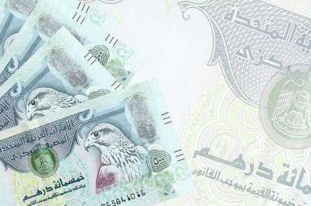 500 UAE dirhams bills lies in stack on background of big semi-transparent banknote. Abstract business background with copy spaceの写真素材