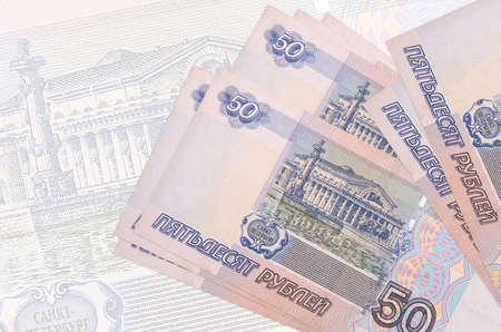 50 russian rubles bills lies in stack on background of big semi-transparent banknote. Abstract presentation of national currency. Business conceptの写真素材