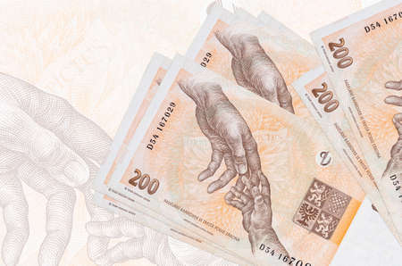 200 Czech korun bills lies in stack on background of big semi-transparent banknote. Abstract...