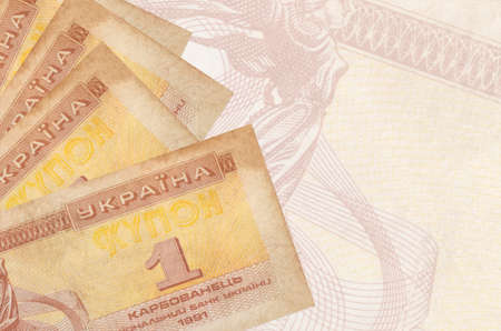 1 Ukrainian coupon bills lies in stack on background of big semi-transparent banknote. Abstract...